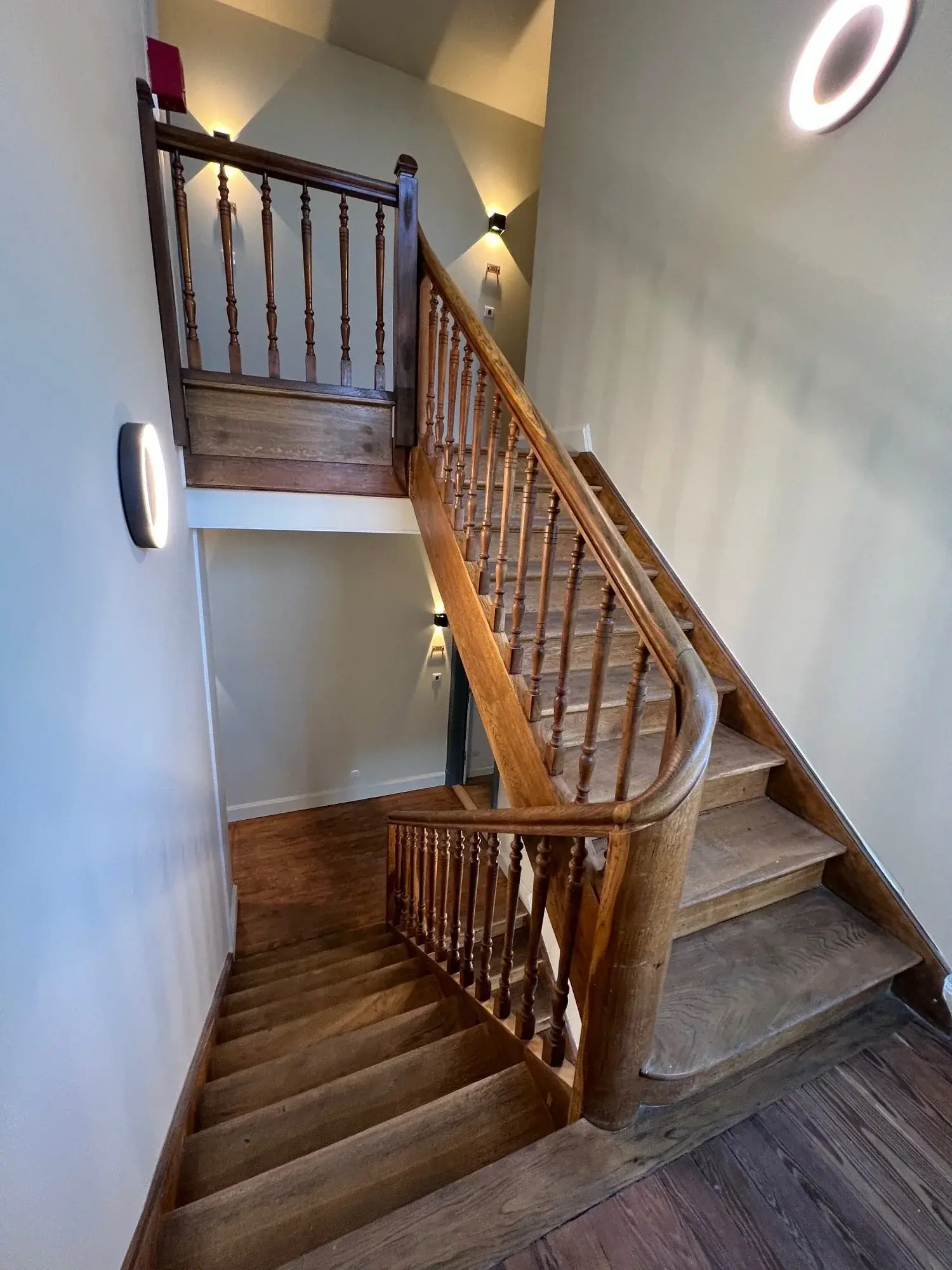 Cage d'escalier ancienne rénovée avec bois naturel et balustres tournés