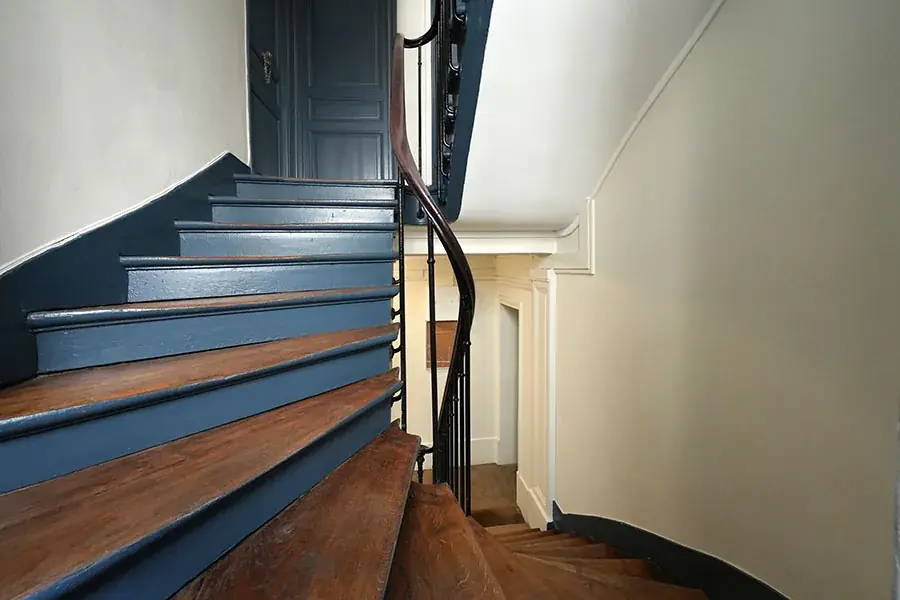 Escalier de copropriété rénové : contremarches bleu nuit et marches en bois naturel