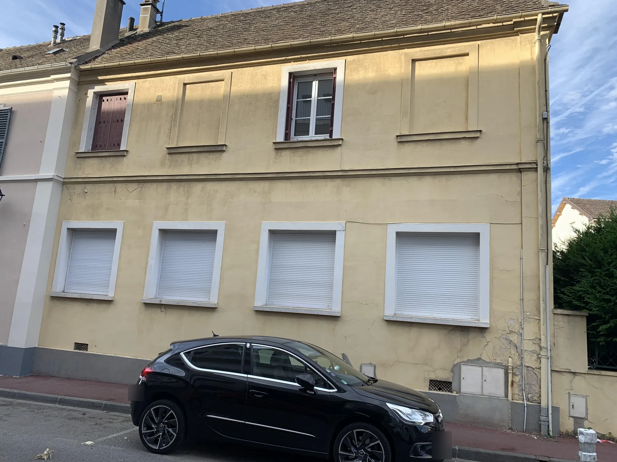 État initial de la façade d'une maison de 1910 avant ravalement à Bezons : ancien enduit ciment peint, fissures et reprises de maçonnerie