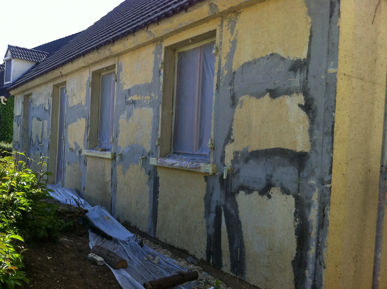 Décapage d'un crépi roulé plastifié et traitement des fissures lors d'un ravalement de façade à Colombes