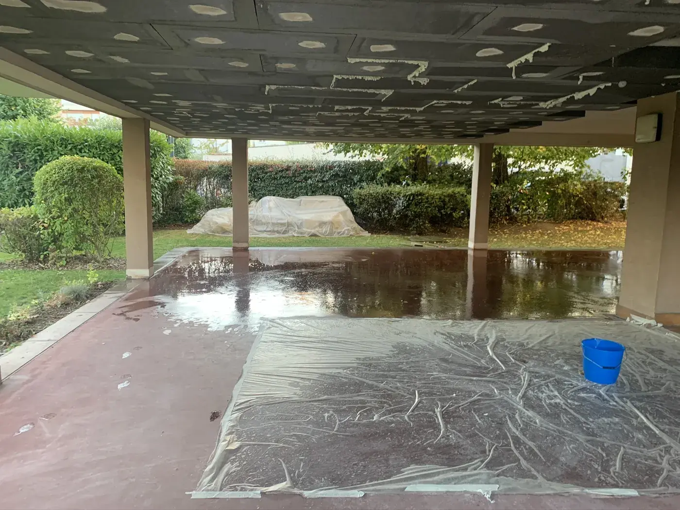 Isolation du plafond d'un porche de copropriété à Enghien-les-Bains, sol protégé pendant les travaux