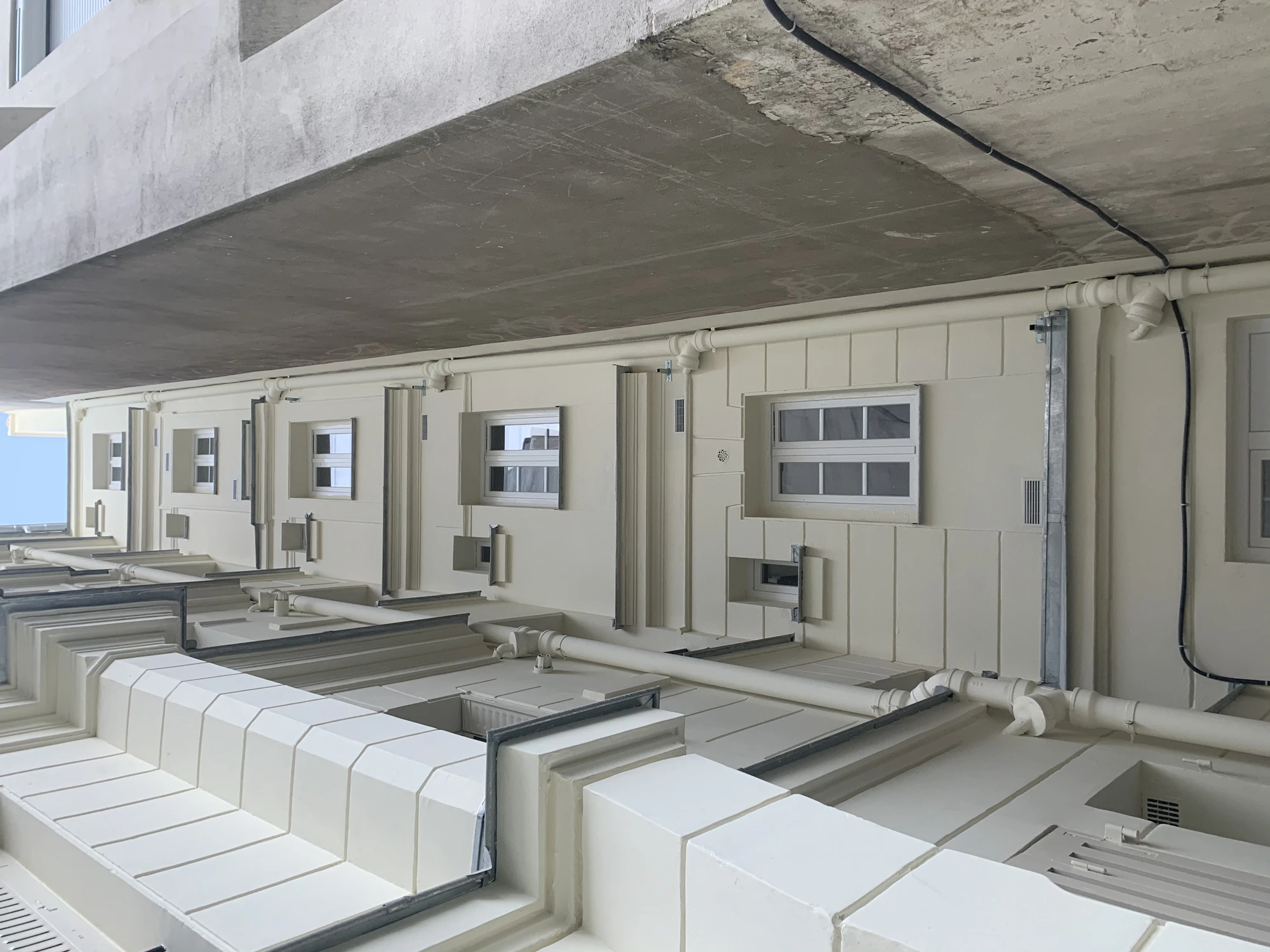 Détail des façades sur cour rénovées d'une copropriété à Paris 5e après ravalement et application du revêtement de finition