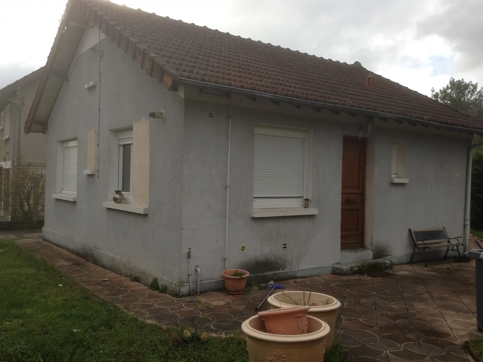 Maison individuelle à Rueil-Malmaison avant travaux : façade encrassée et taches d'humidité en soubassement