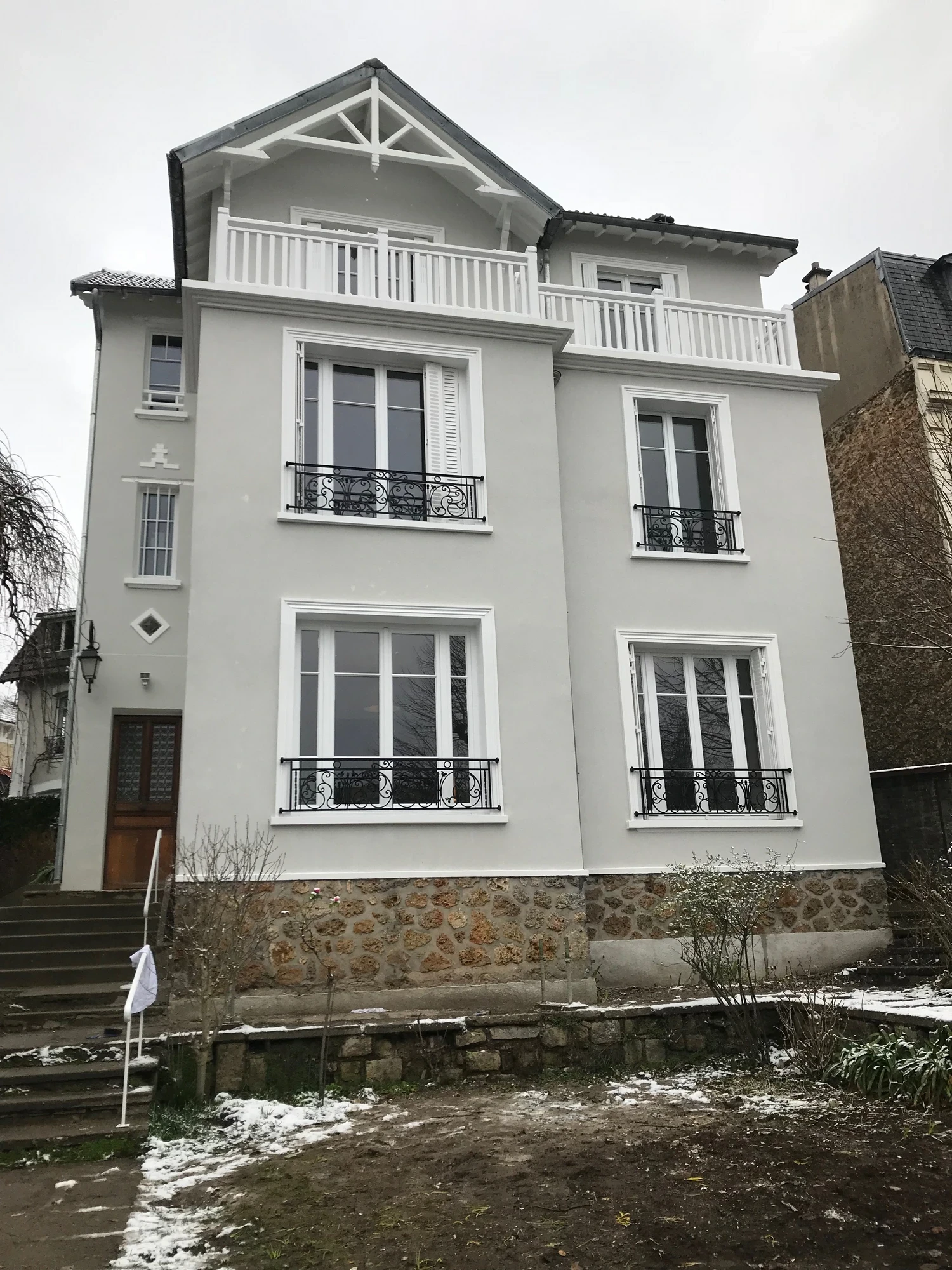 Façade après ravalement à Saint-Cloud : enduit à la chaux, garde-corps en fer et garde-corps bois sur mesure