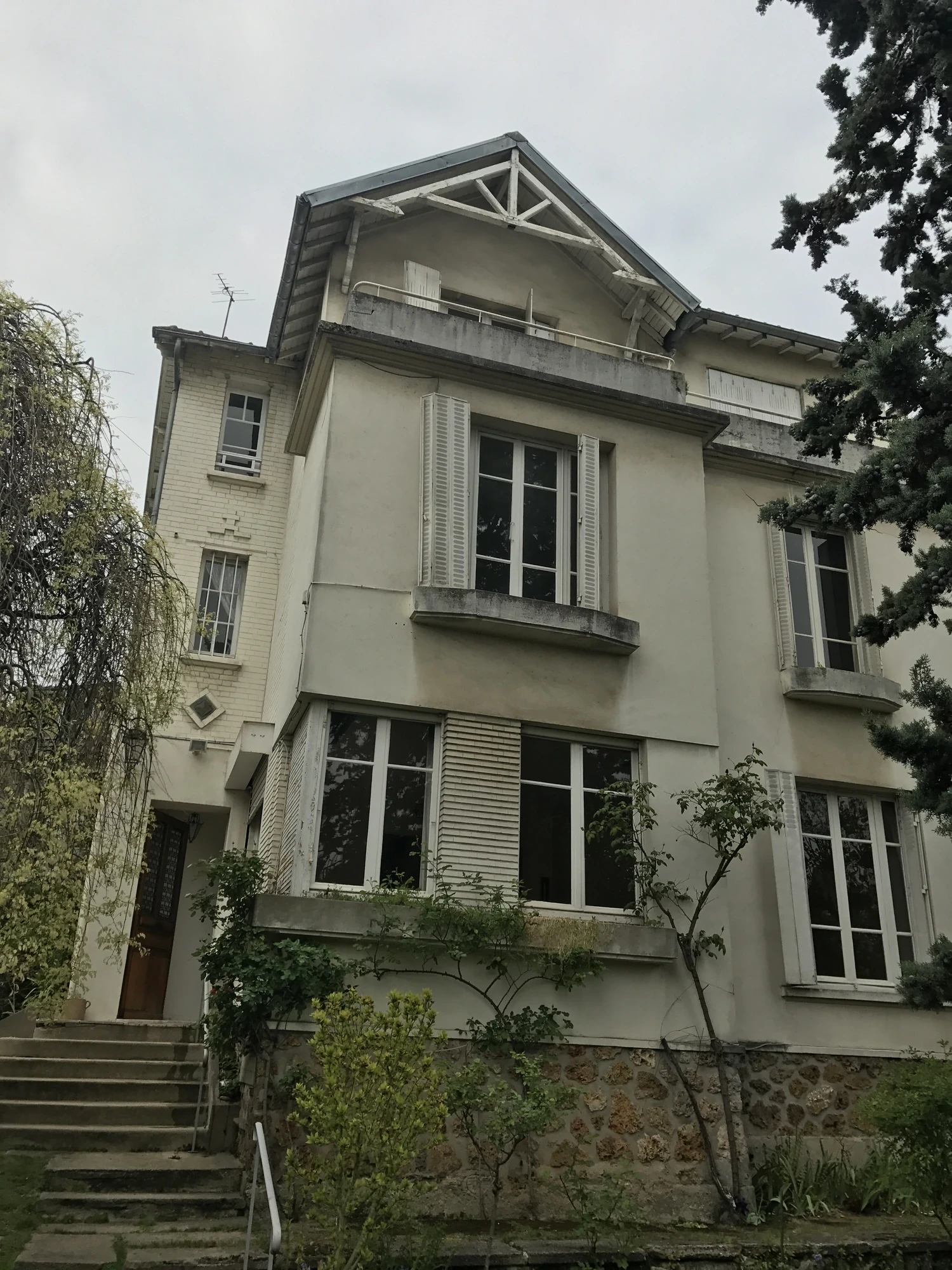Maison à Saint-Cloud avant travaux : façade ancienne ternie, jardinières et balcon en ciment à déposer